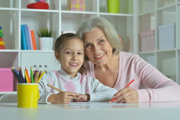 Portret van een gelukkige grootmoeder met kleindochter die samen tekent