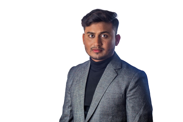 Portret van een gelukkige Indiase jongeman zakenman die een blazer draagt op een grijze achtergrond die een tevreden succesvolle man in een formeel pak stelt