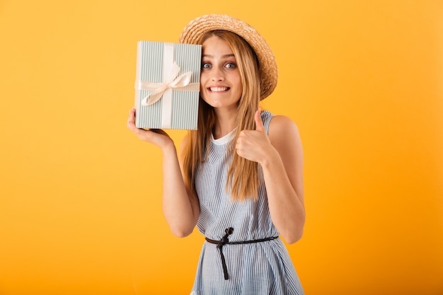 Portret van een gelukkige jonge blonde vrouw in de zomerhoed