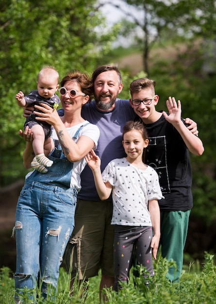 portret van een gelukkige jonge grote hipster-familie terwijl ze picknicken en plezier hebben in de natuur