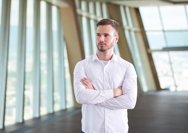 portret van een gelukkige jonge knappe hipster-zakenman met baard bij een modern kantoorruimte-interieur?