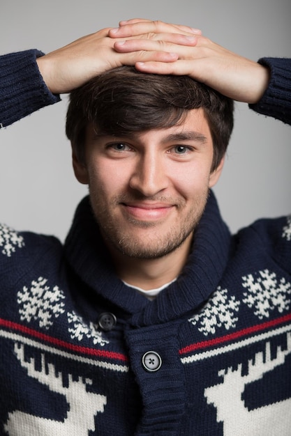 Portret van een gelukkige jonge man in een warm gebreid kerstjack