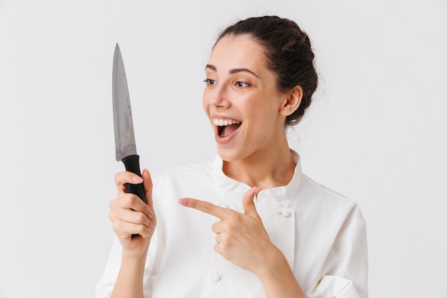 Portret van een gelukkige jonge vrouw met keukengerei