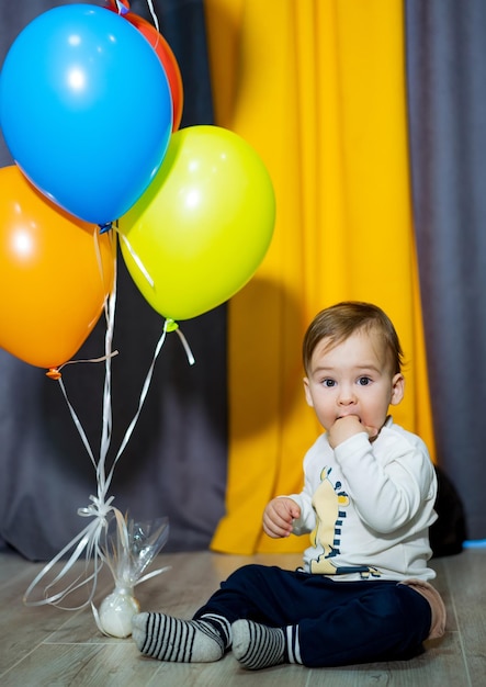 Portret van een gelukkige kleine jongen met kleurrijke ballonnen op de vloer Babyjongen speelt met kleurrijke ballonnen