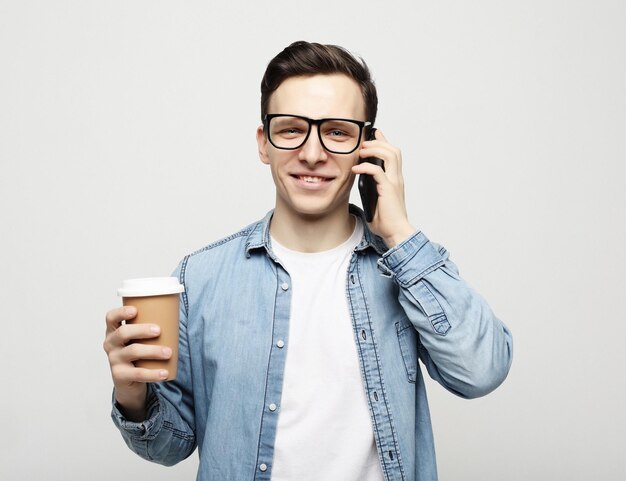 Portret van een gelukkige man die aan de telefoon praat en koffie drinkt