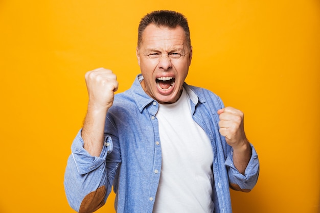 Portret van een gelukkige man van middelbare leeftijd die succes viert