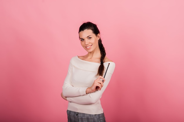 Portret van een gelukkige mooie glimlachende vrouw die haar gezicht aanraakt, geïsoleerd tegen blauwe en roze achtergrond