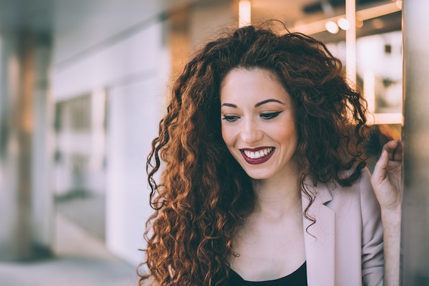 Portret van een gelukkige mooie jonge roodharigevrouw