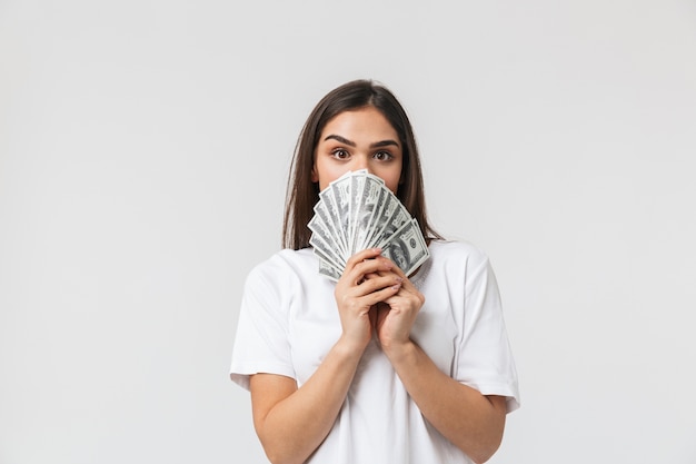 portret van een gelukkige mooie jonge vrouw casualy gekleed geïsoleerd op wit, met geld bankbiljetten