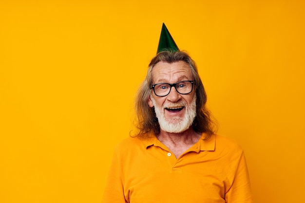 Foto portret van een gelukkige senior man in een gele t-shirt met een pet op zijn hoofd leuke gele achtergrond