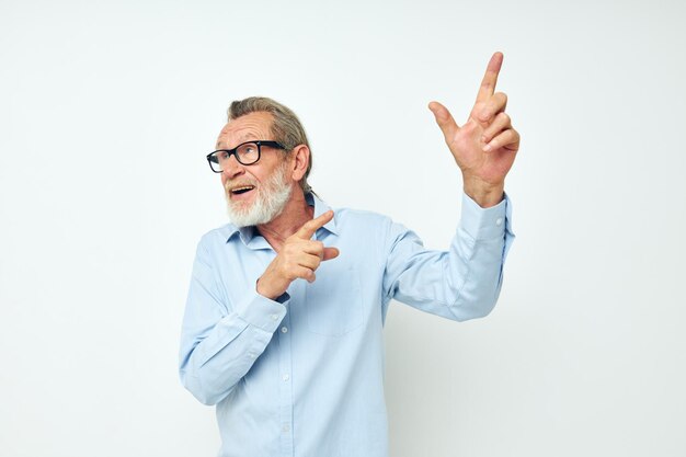 Portret van een gelukkige senior man in shirt en bril die emoties stelt bijgesneden weergave