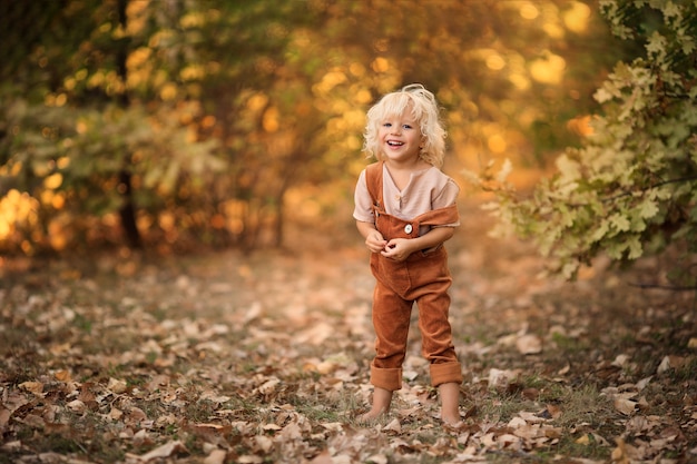 Portret van een gelukkige vrolijke jongen die in het bos loopt