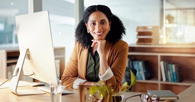 Portret van een gelukkige vrouw bij de computer met een glimlach vertrouwen en carrière in de administratie bij een digitaal agentschap Internet desk en zakenvrouw bij een tech startup met een creatieve baan voor professioneel bedrijf