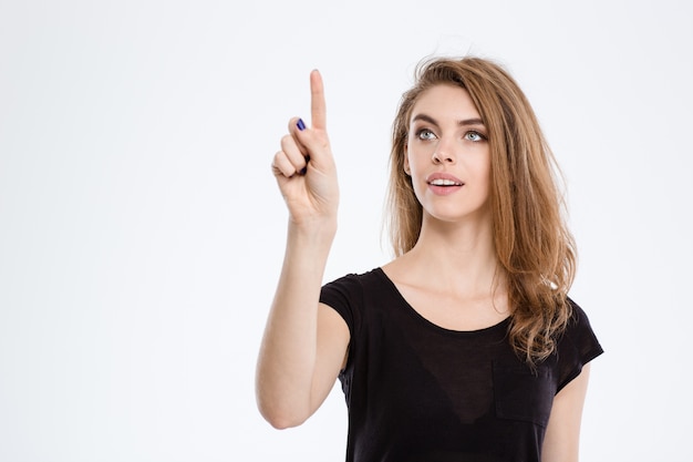 Portret van een gelukkige vrouw die een onzichtbaar scherm aanraakt dat op een witte achtergrond wordt geïsoleerd