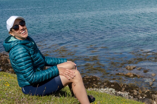 Portret van een gelukkige vrouwelijke reiziger die lacht op het strand