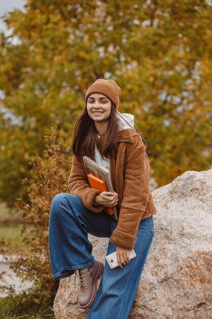 Foto portret van een gelukkige vrouwelijke student met een laptop die naar de camera kijkt in het park
