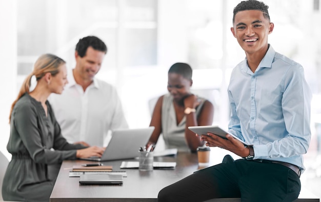 Portret van een gelukkige zakenmanglimlach met een tablet in een teamplanningsvergadering op het werk Een werknemer in een kantoor met zijn team terwijl ze strategie of plannen en strategieën in een hoofdkantoor bespreken