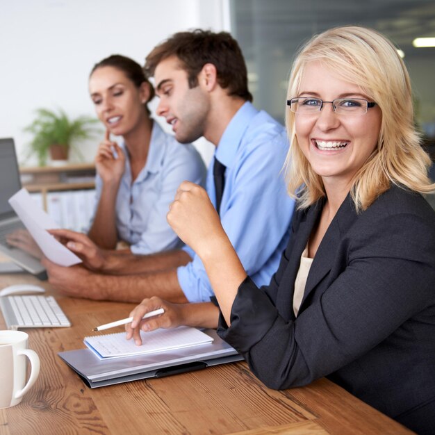 Foto portret van een gelukkige zakenvrouw in een coworkingruimte zelfvertrouwen en carrière in een marktonderzoeksbureau teamleider professionele mensen en projectmanager aan het bureau met een glimlach op het gezicht in een personeelsworkshop