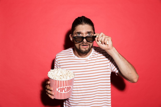 Portret van een geschokte man in een 3D-bril die naar film kijkt