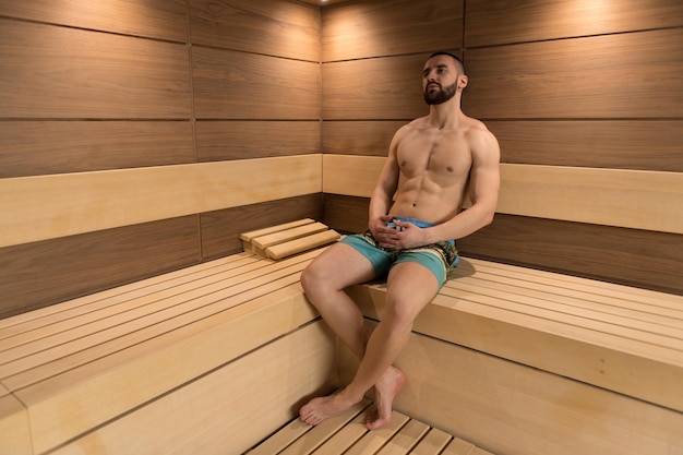 Portret van een gespierde man die ontspant in de sauna