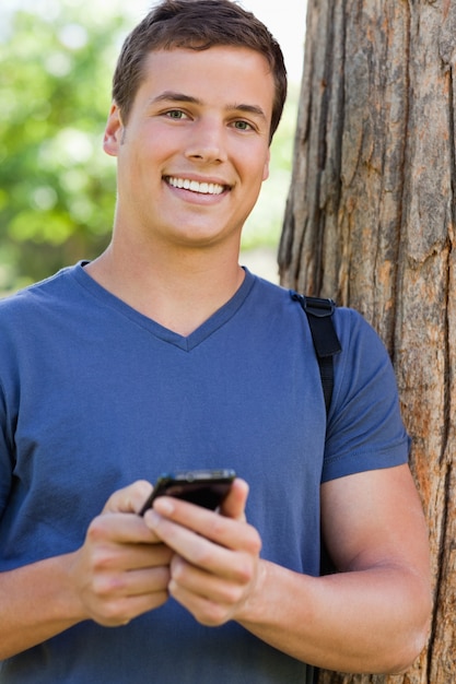 Portret van een gespierde student met een smartphone