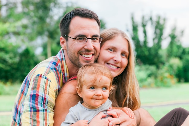 Portret van een gezin dat op het gras zit in de achtertuin