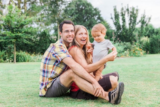 Portret van een gezin dat op het gras zit in de achtertuin