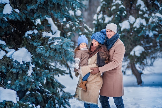 portret van een gezin tegen de achtergrond van met sneeuw bedekte bomen