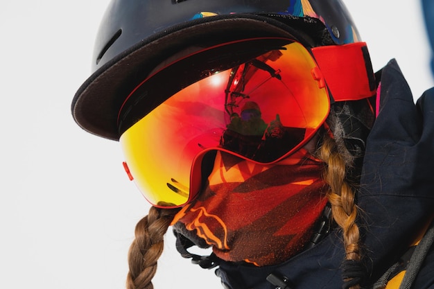 Portret van een gezonde jonge vrouw in een sportmasker en helm die de wintervakantie doorbrengt in de sneeuw