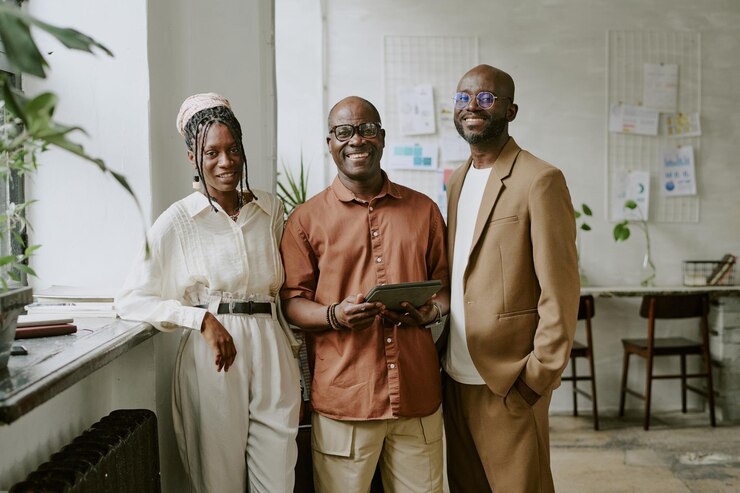 Portret van een glimlachend Afro-Amerikaans team dat poseert voor een foto in een modern kantoor