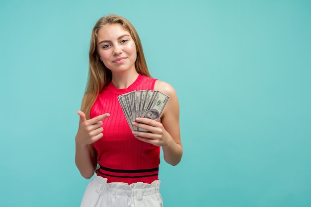 Portret van een glimlachend meisje dat op bos geld richt