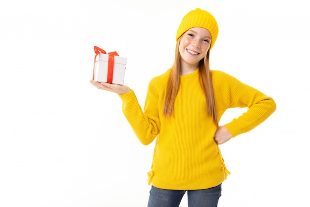Portret van een glimlachend meisje met een gift in één hand op een wit