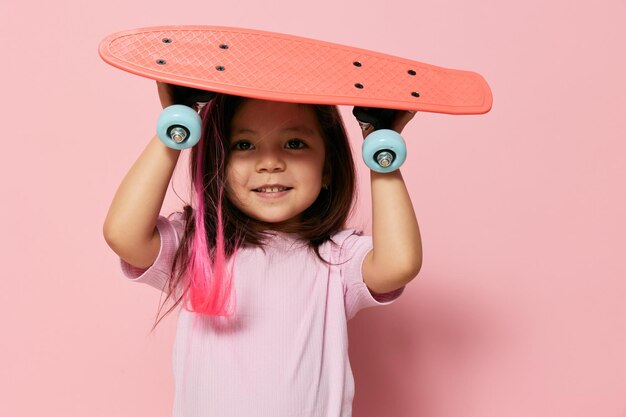 Foto portret van een glimlachend meisje met speelgoed op een roze achtergrond