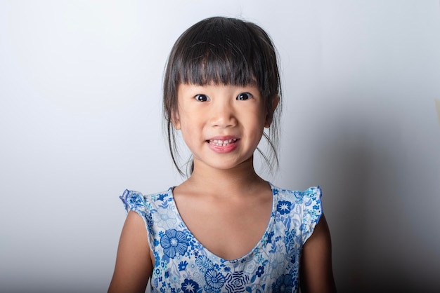Portret van een glimlachend meisje tegen een witte achtergrond