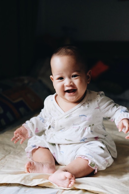 Portret van een glimlachend schattig baby meisje dat thuis zit