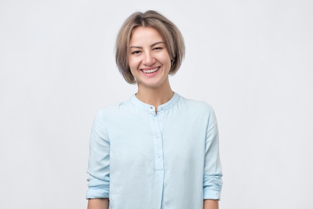 Portret van een glimlachende aantrekkelijke vrouw met kort stijlvol kapsel