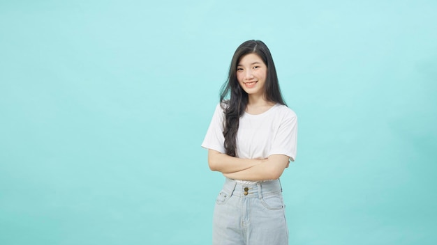 Portret van een glimlachende Aziatische studentenvrouw die naar camera kijkt, geïsoleerde blauwe achtergrond