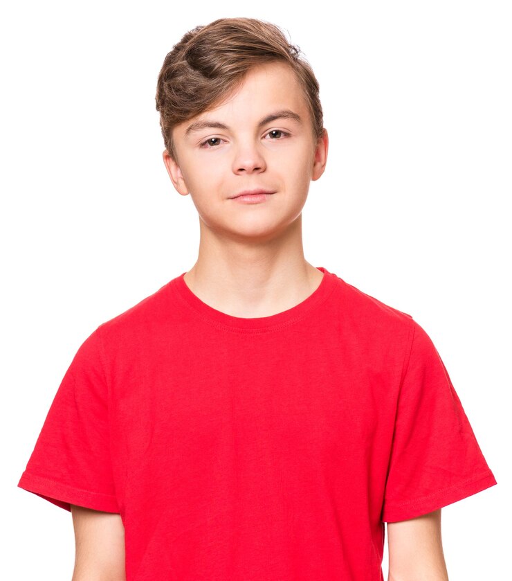 Foto portret van een glimlachende blanke tienerjongen een knappe tiener met een rood t-shirt geïsoleerd op een witte achtergrond een gelukkig kind dat naar de camera kijkt