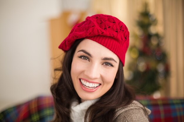 Portret van een glimlachende brunette in hoed bij Kerstmis