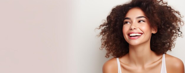 Portret van een glimlachende gelukkige jonge vrouw op een witte achtergrond.