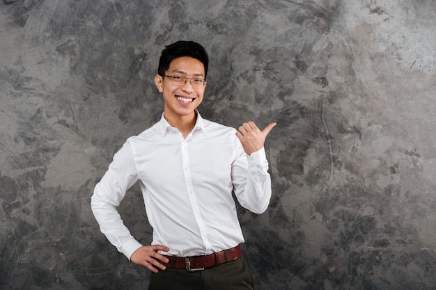 Portret van een glimlachende jonge Aziatische mens gekleed in overhemd