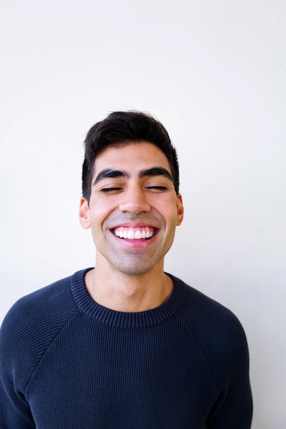 Portret van een glimlachende jonge man op een witte achtergrond