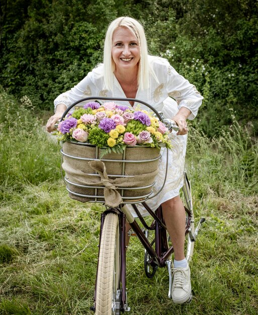 Foto portret van een glimlachende jonge vrouw die bij een stenen muur staat