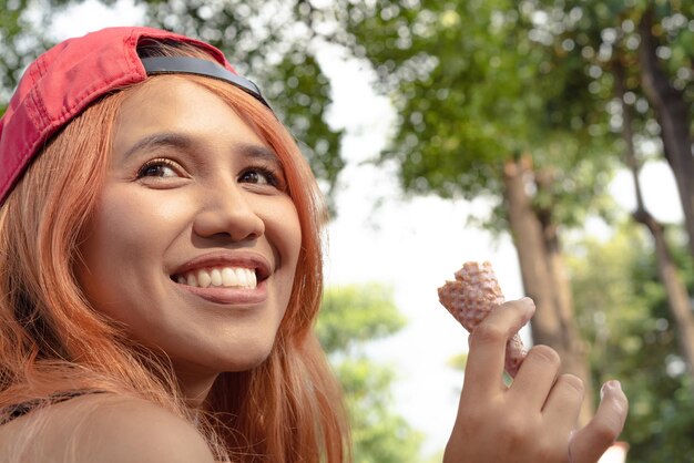 Portret van een glimlachende jonge vrouw die buiten houdt