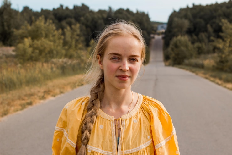 Foto portret van een glimlachende jonge vrouw die buiten staat