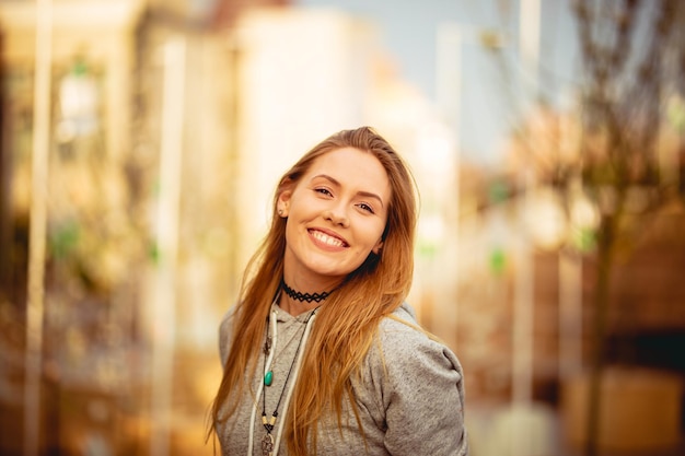 Portret van een glimlachende jonge vrouw die buiten staat