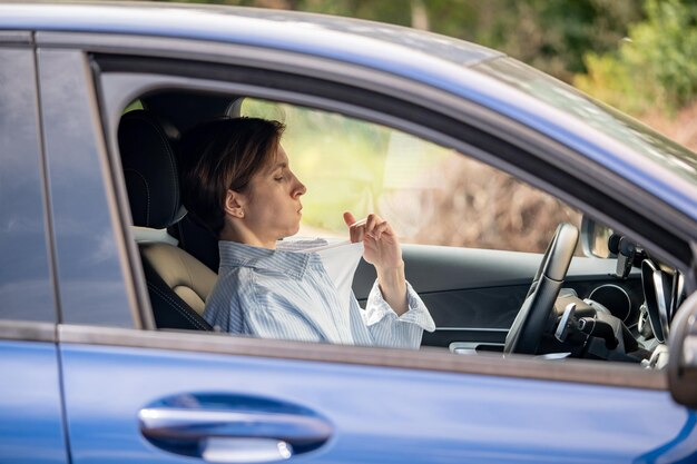 Portret van een glimlachende jonge vrouw die in de auto zit