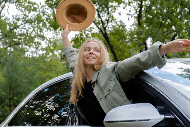 Foto portret van een glimlachende jonge vrouw die in een auto zit