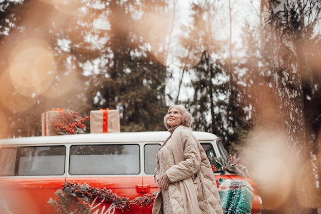 Foto portret van een glimlachende jonge vrouw die op een auto zit