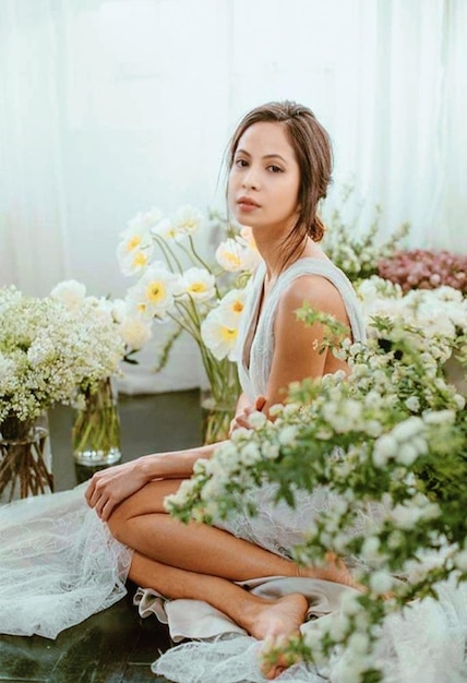 Portret van een glimlachende jonge vrouw die op tafel zit